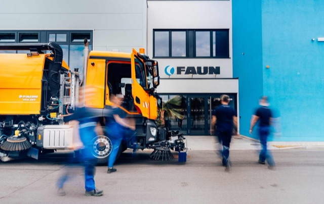 Werksgebäude von FAUN mit Kehrmaschinen und Mitarbeitern davor