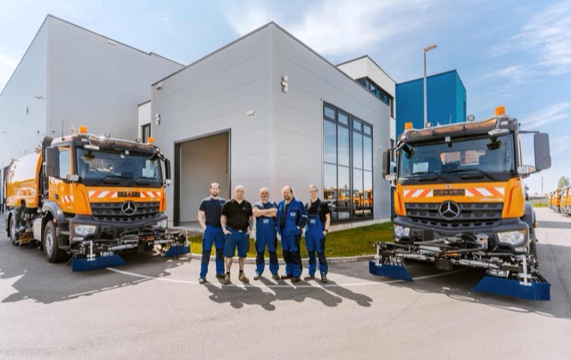 FAUN-Team vor dem Werk in Grimma zwischen zwei Kehrmaschinen