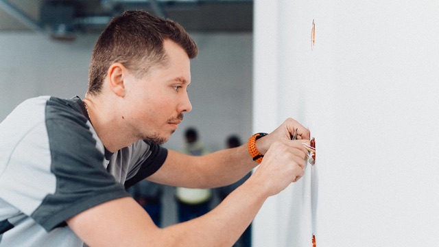 Elektriker der FEST GmbH bei der Installation an der Wand