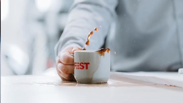 Kaffeetasse mit FEST-Logo in der Hand