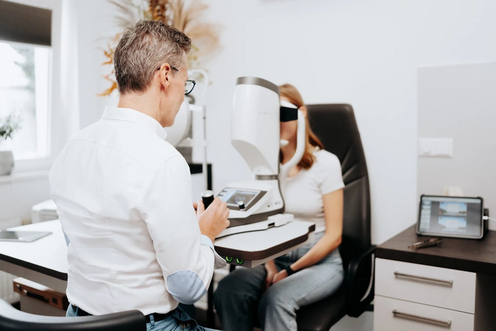 Augenoptiker bei der Sehprüfung einer Kundin