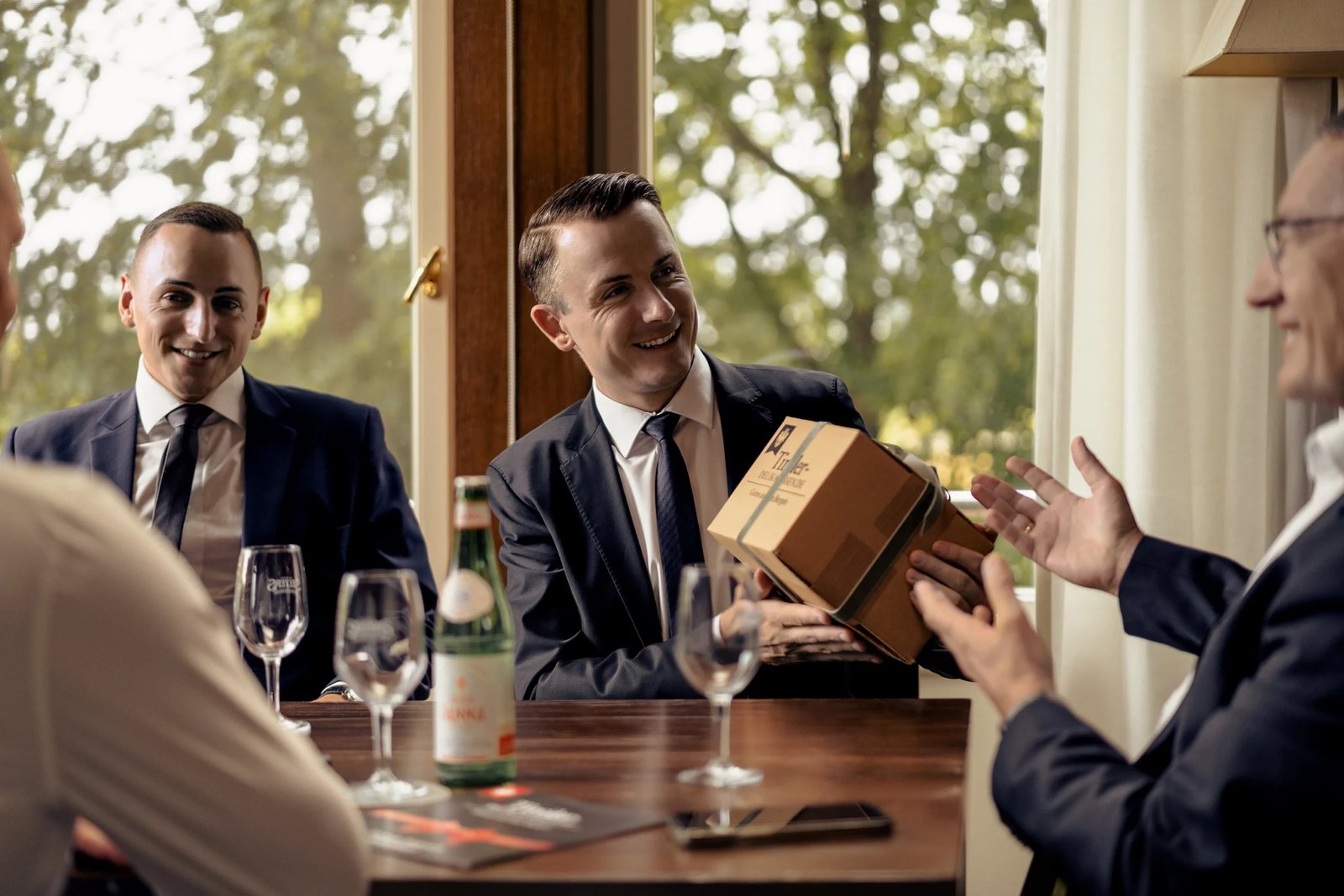 Geschäftsessen: Ein Gast überreicht eine Box von Tiroler Delikatessen