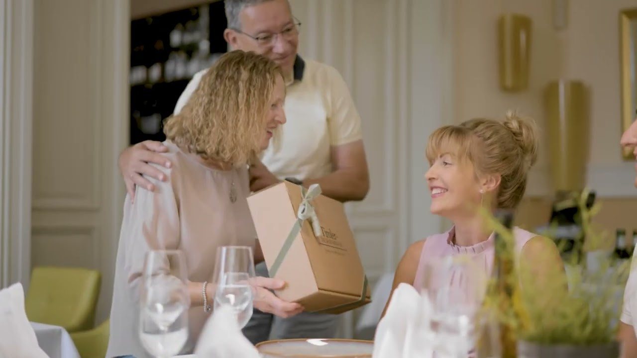 Standbild aus dem Imagefilm für Tiroler Delikatessen: Eine Geschenkbox wird am gedeckten Tisch überreicht